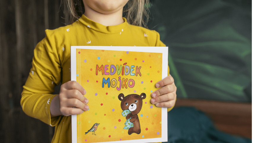 dětské ruce drží knihu Medvídek Mojko
